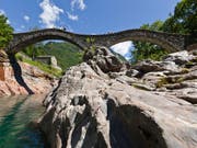 Bei der so genannten Römerbrücke in Lavertezzo im Verzascatal ist eine Italienerin von der Strömung mitgerissen und schwer verletzt worden. (Bild: KEYSTONE/GAETAN BALLY)