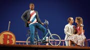Per Velo zu Diensten: Figaro (Martin Mkhize) mit Almaviva (Linard Vrielink) und Rosina (Svetlina Stoyanova). (Bild: Karl Forster/Bregenzer Festspiele)
