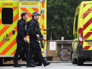 Schwer bewaffnete Polizisten am Dienstag in der Nähe des Tatorts. (Bild: Keystone/EPA/ANDY RAIN)