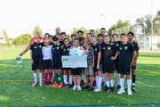 Jaime kann sein Glück kaum fassen. Umringt von seinen Teamkollegen präsentiert er den Check, welcher der ganzen Familie ein Besuch im Fussballstadion in Manchester ermöglicht. (Bild: Daniela Ebinger)