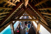 Touristen auf der Kapellbrücke. Nur wenige blicken nach oben in die leeren Brückengiebel. (Bild: Philipp Schmidli (Luzern, 29. Juli 2018))