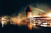 Gespenstischer Anblick: Die brennende Kapellbrücke mitten in der Nacht – die Löscharbeiten sind noch im Gang. Es ist das meist abgedruckte Bild des Brandes. (Bild: Ruth Tischler (Luzern, 18. August 1993))