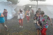 Das Festzelt ist nicht mehr sicher: Besucher der 1.-August-Feier in Staad flüchten durch den Regen. (Bild: Max Tinner)