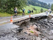 Touristen bei einer unterspülten Strasse in Saalbach-Hinterglemm am Freitag. (Bild: Keystone/APA/APA/EXPA/JFK)