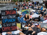 Auf einer Brücke legten sich die Demonstranten auf den Boden, um an die Qualen gefangener Fische zu erinnern. (Bild: KEYSTONE/MARTIAL TREZZINI)