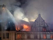 Die Feuerwehr bekämpft den Brand von Drehleitern aus von allen Seiten. Das Gebäude in der Nähe des Zürcher Hauptbahnhofs. (Bild: KEYSTONE/ENNIO LEANZA)