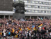 Rechte Gruppierungen versammelten sich am Montagabend bei der Karl-Marx-Statue in Chemnitz. (Bild: EPA/FILIP SINGER)