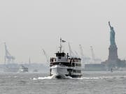 Touristen werden wegen eines Brandes in der Nähe der Freiheitsstatue in New York evakuiert. (Foto: Jason Szenes/EPA) (Bild: KEYSTONE/EPA/JASON SZENES)