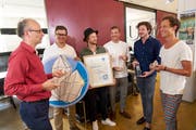 Michael Töngi, Mitglied des Alpenrats der Alpeninitiative, übergibt den Preis an die Mitglieder des Vereins Wasser für Wasser. (Bild: PD)