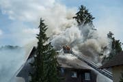 Die Feuerwehrleute bekämpfen den Brand von der Drehleiter aus. (Bild: Dominik Wunderli (Reiden, 29. August 2018))