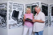 Roland Schlumpf und Judith Wild blättern im 50-Jahr-Jubiläumsbuch des Burgbachkellers Zug. (Bild: Maria Schmid ( Zug, 23. August 2018 ))