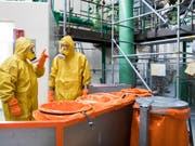 Zur Jahresrevision gehört auch, dass Angestellte in Schutzanzügen Bestandteile des Reaktors untersuchen und warten. (Bild: KEYSTONE/PETER KLAUNZER)