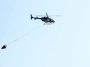 Lösch-Helikopter beim Rettungseinsatz in Hergiswil. (Bild: KEYSTONE/URS FLUEELER)