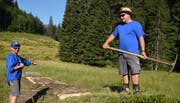 Ein Stück Prügelweg im «Rotibachried» auf der Alp Längenfeldmoos ist saniert. Vereinspräsident Tobias Pfister (links) und Vorstandsmitglied Silvan Gasser sind zufrieden. Bild: Robert Hess, Alpnach, 3. August 2018)