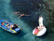 Gegen die Bruthitze kann nur noch ein Bad im kühlen Fluss helfen. Hier eine Momentaufnahme aus der Rohne in Genf. (Bild: Keystone/SALVATORE DI NOLFI)
