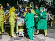 Patienten werden aus Angst vor Erdbeben aus einem Spital in Denpasar, Bali, gebracht. (Bild: KEYSTONE/EPA/MADE NAGI)