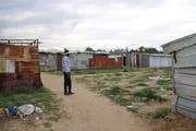 Drame Madiheri steht vor der «Baulücke» im Slum von San Ferdinando, wo seine Kollegin Becky Moses im Januar bei lebendigem Leib verbrannt ist. (Bild: Dominik Straub)