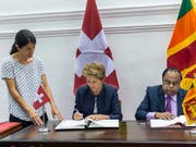 Bundesrätin Simonetta Sommaruga (Mitte) und der Innenminister von Sri Lanka, Seneviratne Bandara Nawinne (rechts), unterzeichnen das Memorandum of Understanding über eine Migrationspartnerschaft in Colombo. (Bild: KEYSTONE/PATRICK HUERLIMANN)