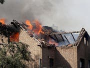 Flammen schlagen aus den Dachstühlen brennender Häuser an der Bahnstrecke in Siegburg. (Bild: Keystone/DPA/OLIVER BERG)