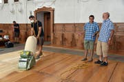 Ein Mitarbeiter der Firma Schoonwater Parkett aus Kerns schleift den Boden der Kirche ab. Ganz rechts Aushilfssigrist Sepp Oberholzer im Gespräch mit Hugo von Atzigen von der gleichnamigen Schreinerei (Bilder: Robert Hess (Alpnach, 6. August 2018))