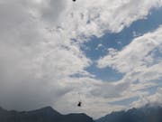 Ein Superpuma transportiert den beschädigten Helikopter nach der Kollision mit einem Heu-Seil im Schächental ab. (Bild: Kantonspolizei Uri)