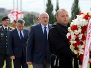 Präsident Giorgi Margwelaschwili (M) legte auf einem Friedhof bei Tiflis einen Kranz zum Gedenken an die getöteten georgischen Soldaten nieder. (Bild: KEYSTONE/EPA/ZURAB KURTSIKIDZE)