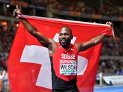 Alex Wilson feiert mit Schweizer Fahne seine Bronzemedaille (Bild: KEYSTONE/AP/MARTIN MEISSNER)