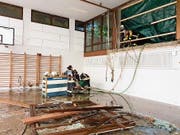 Nach dem schlimmen Unwetter von 8. Juni: Feuerwehrleute pumpen Wasser aus der unteren Reutenen-Turnhalle. (Bild: PD)