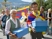 Mitglieder der Gesellschaft für bedrohte Völker (GfbV) und Tibet-Organisationen reichen bei der Bundeskanzlei eine Petition ein, mit der sie Politik und Behörden auffordern, die Grundrechte der Tibeterinnen und Tibeter in der Schweiz zu schützen. (Bild: KEYSTONE/ALESSANDRO DELLA VALLE)
