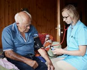Sara Barmettler misst bei einem Klienten den Blutdruck. (Bild: Herbert Zimmermann)