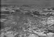 Das verschneite St.Gallen auf einer Luftaufnahme von Foto Gross im Jahr 1956. Vorne ist der Osten der Stadt - mit Fussballstadion Krontal links und Fussballstadion Espenmoos in der Mitte) - zu erkennen. Hinter der ehemaligen Gemeinde Tablat kommt das Stadtzentrum, die alte Stadt St.Gallen. Und im Westen sind als Haufendörfer links und rechts des Sittergrabens Bruggen und Winkeln noch zu erahnen. (Bild: Stadtarchiv Ortsbürgergemeinde St.Gallen/Sammlung Foto Gross)