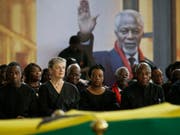 Kofi Annans Sohn Kojo Annan (l.) seine Witwe Nane Annan (2.v.l.), Tochter Ama Annan (M) und weitere Familienmitglieder am Donnerstag am Sarg des früheren Uno-Generalsekretärs. (Bild: Keystone/AP/SUNDAY ALAMBA)