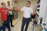 In seinem Spritzwerk erläuterte Inhaber Bekim Kurtisi den Gästen, wie man Farben sorgfältig auf eine Fläche aufträgt. (Bild: Christof Lampart)