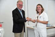 Ernst Marty, Facharzt für Gynäkologie, überreicht Chefärztin Andrea Müller Reid symbolisch eine Geburtszange. (Bild: Urs Hanhart, Altdorf, 14. September 2018)