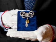 Eine Brosche, die einst im Besitz der französischen Königin Marie-Antoinette war, wird bei einer Präsentation von Juwelen aus dem Haus Bourbon-Parma beim Auktionshaus Sotheby's von einem Mitarbeiter gehalten. Die Versteigerung ist für den 14. November 2018 angekündigt. (Bild: Keystone/DPA/TOBIAS HASE)