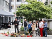 Passanten legen am Tatort Blumen nieder. Nach einem Streit war am 26. August in der Innenstadt von Chemnitz ein 35-jähriger Mann erstochen worden. (Bild: Keystone/DPA ZB/JAN WOITAS)