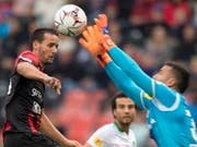 Xamax-Spieler Raphael Nuzzolo kommt gegen St. Gallens Keeper Dejan Stojanovic zu spät (Bild: KEYSTONE/LAURENT GILLIERON)