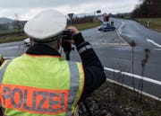 Ein Polizist kontrolliert Gottmadingen am Ende der Autobahn A81 mit einem Lasermessgerät die Geschwindigkeit der Fahrzeuge. Auf der A81 nahe der Schweizer Grenze kommt es häufig zu illegalen Autorennen. (Bild: DPA)