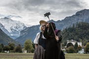 Eine Touristin mit Niqab macht auf der Höhenmatte in Interlaken vor der Jungfrau ein Selfie mit einer Frau in Tracht, aufgenommen am 4. Oktober 2017. (Bild: Keystone/Rolf Neeser)