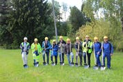 Der erste Spatenstich fand auf einer Wiese statt, durch die die neue Wasserleitung verlaufen wird. Der Holzstab mit rotem Ende zeigt das an. (Bild: Martin Knoepfel)