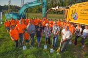 Vier Generationen der Familie Greminger mit Geschäftsführer Simon (graues Hemd) führen mit Architekt Thomas Kaczmarek und Gemeindepräsident Ruedi Zbinden den Spatenstich für ihren neuen Werkhof aus. (Bild: Mario Testa)