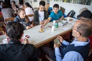 Am einen Tisch legen die Teilnehmer des Migrationstreffs fleissig «Uno»-Karten ab. (Bilder: Reto Martin)