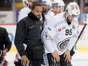 Luganos Verteidiger Thomas Wellinger wird von einem Staff-Mitglied vom Eis begleitet (Bild: KEYSTONE/DANIEL TEUSCHER)