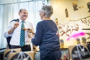 Vögeli trifft auf Vögeli: Marianne Boltshauser vom Geschenkladen Frappant steckt dem Gemeindepräsidenten einen Deko-Vogel an. (Bild Andrea Stalder)