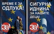 Passanten vor einem Kampagnen-Plakat in Skopje. (Bild: Boris Grdanoski/AP (27. September 2018)