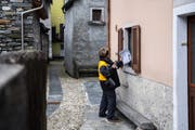 Um solche Dienstleistungen fürchtet die SP: Eine Pöstlerin übergibt einer Kundin ihre Briefe durchs Fenster. Bild: Samuel Golay/Keystone