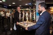Store-Manager Heerbrugg Italo Tempini (rechts) und Manora-Gerant Remo Hug bringen die Geburtstagstorte. (Bild: Susi Miara)