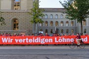 Menschen demonstrieren waehrend der Aktion von Arbeitnehmenden zum Arbeitnehmerrecht "Rote Linie Arbeitnehmerrechte", am Mittwoch, 5. September 2018 vor dem Bundeshaus in Bern. (KEYSTONE/Anthony Anex)