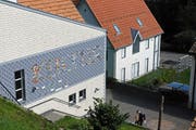 Ralf Brühwiler versieht die Krinauer Schulhausfassade mit Holzschindelmotiven. (Bild: Michael Hug)
