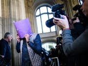 Die mutmasslichen Diebe der 100 Kilogramm schweren Goldmünze «Big Maple Leaf», die sie im März 2017 aus dem Berliner Bode-Museum gestohlen haben sollen , mussten zum Prozessauftakt am Donnerstag in Berlin durch ein Spalier von Journalisten. (Bild: KEYSTONE/EPA/CLEMENS BILAN)